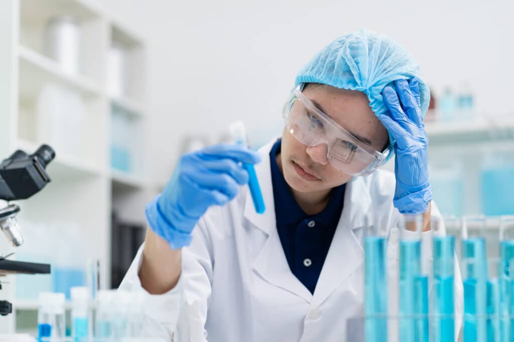 disgruntled and upset lab technician holding ruined research sample due to disaster that could be prevented by monitoring and a failure alarm for freezer 