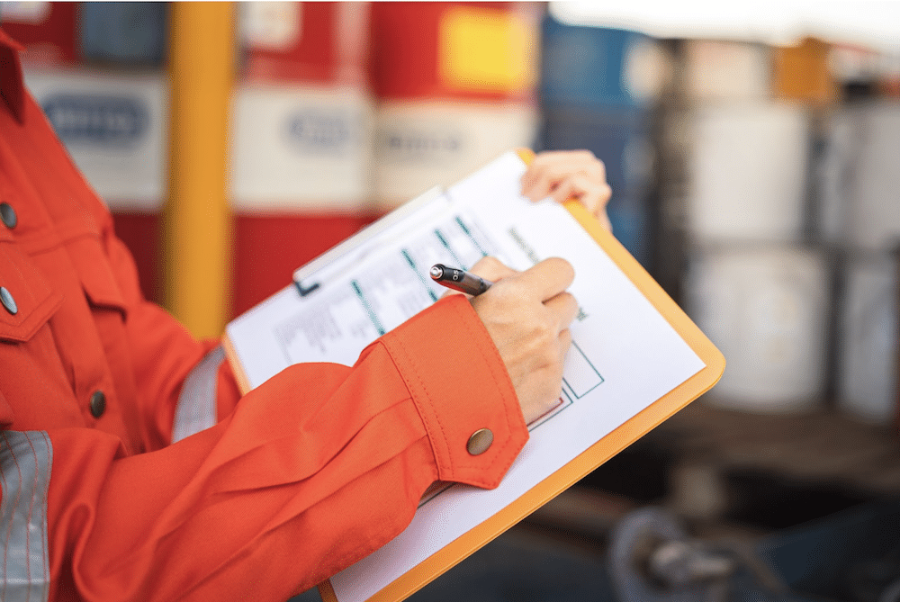 OSHA staff member filling out an inspection report to prevent heat related illness on a job site